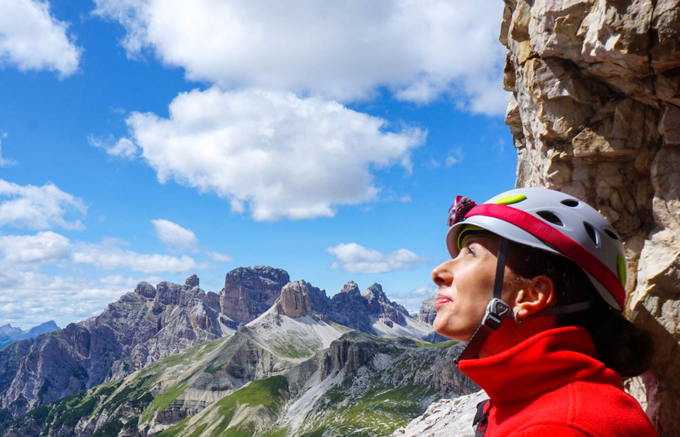 Primo piano di volto di ragazza escursionista con caschetto che ammira il panorama delle montagne dell'Alto Adige