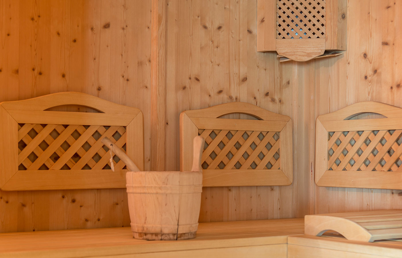Seduta e pareti in legno naturale all'interno della sauna finlandese dell'Hotel Waldheim