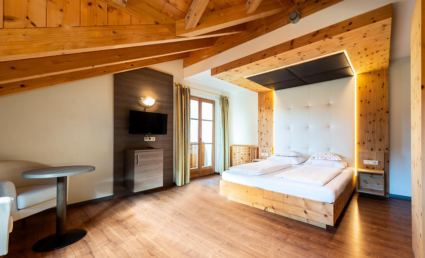 Doppelbett aus Naturholz in einem Zimmer des Hotel Waldheim in Südtirol, Italien.