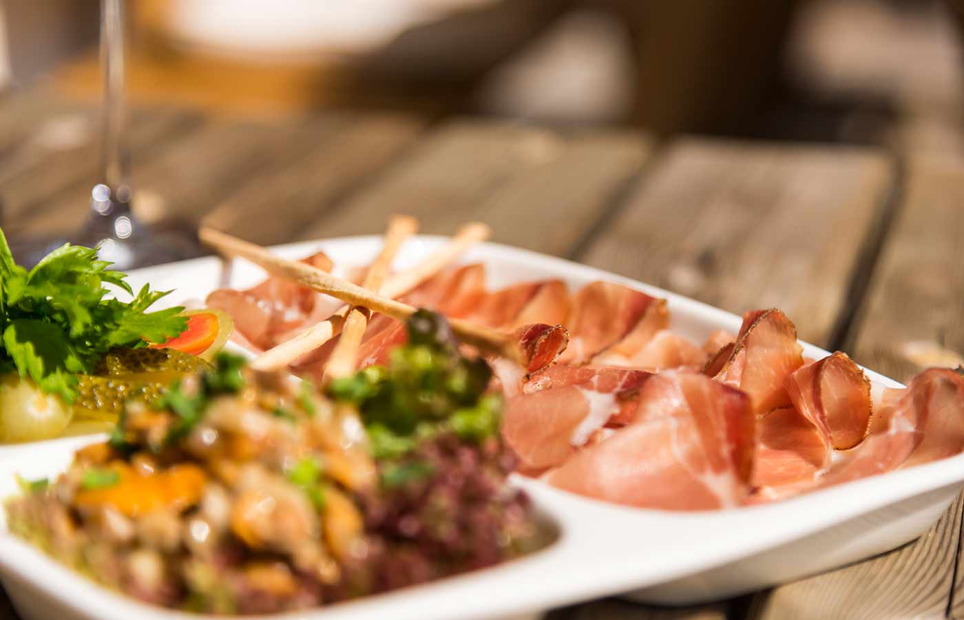 close-up of a plate of bacon, gherkins and aperitif snacks