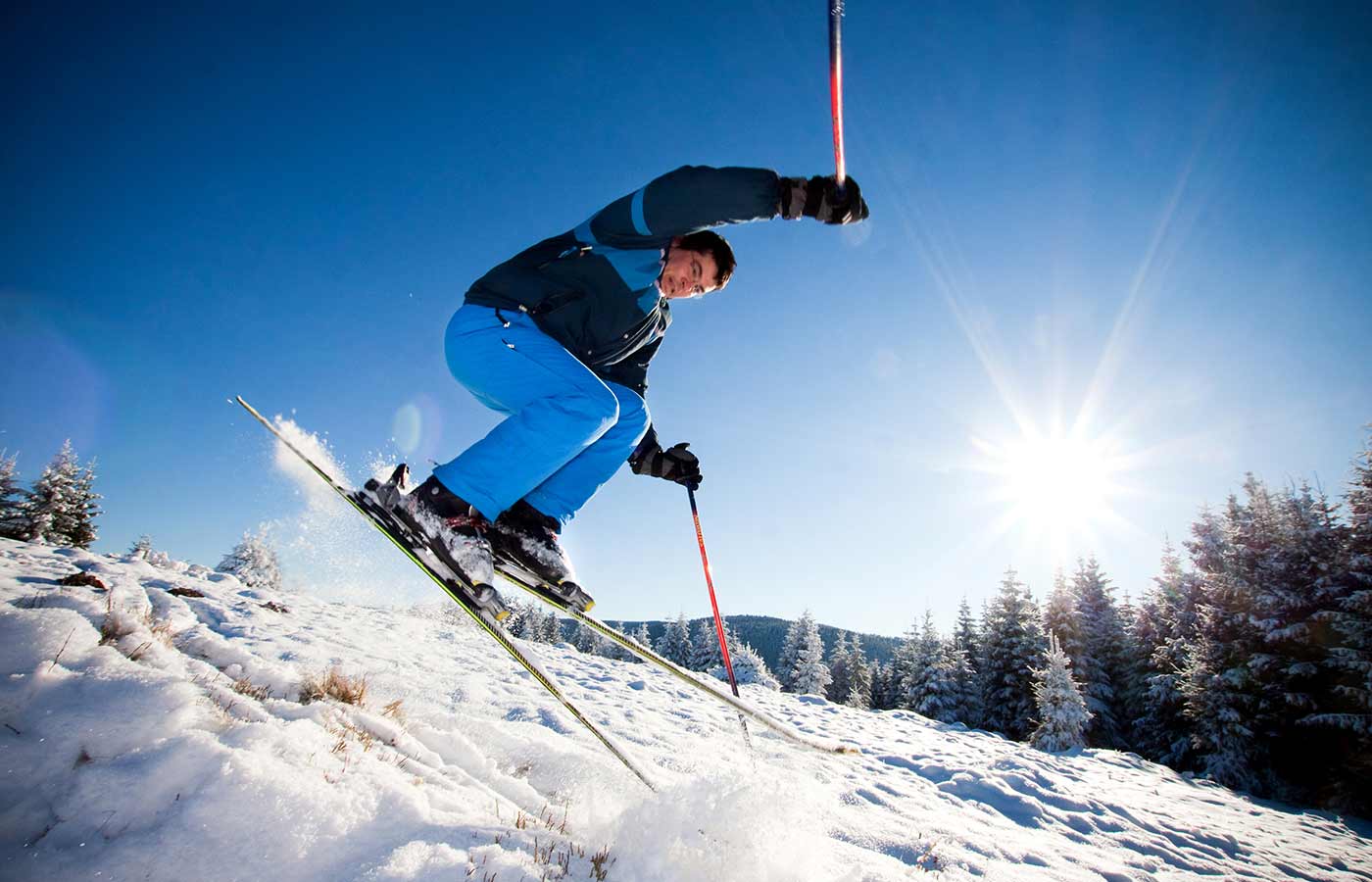 Sciatore che fa acrobazie nella neve in una soleggiata giornata d'inverno