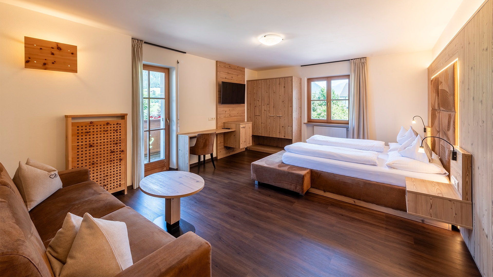 Doppelbett aus Naturholz in einem Zimmer des Hotel Waldheim in Südtirol, Italien.