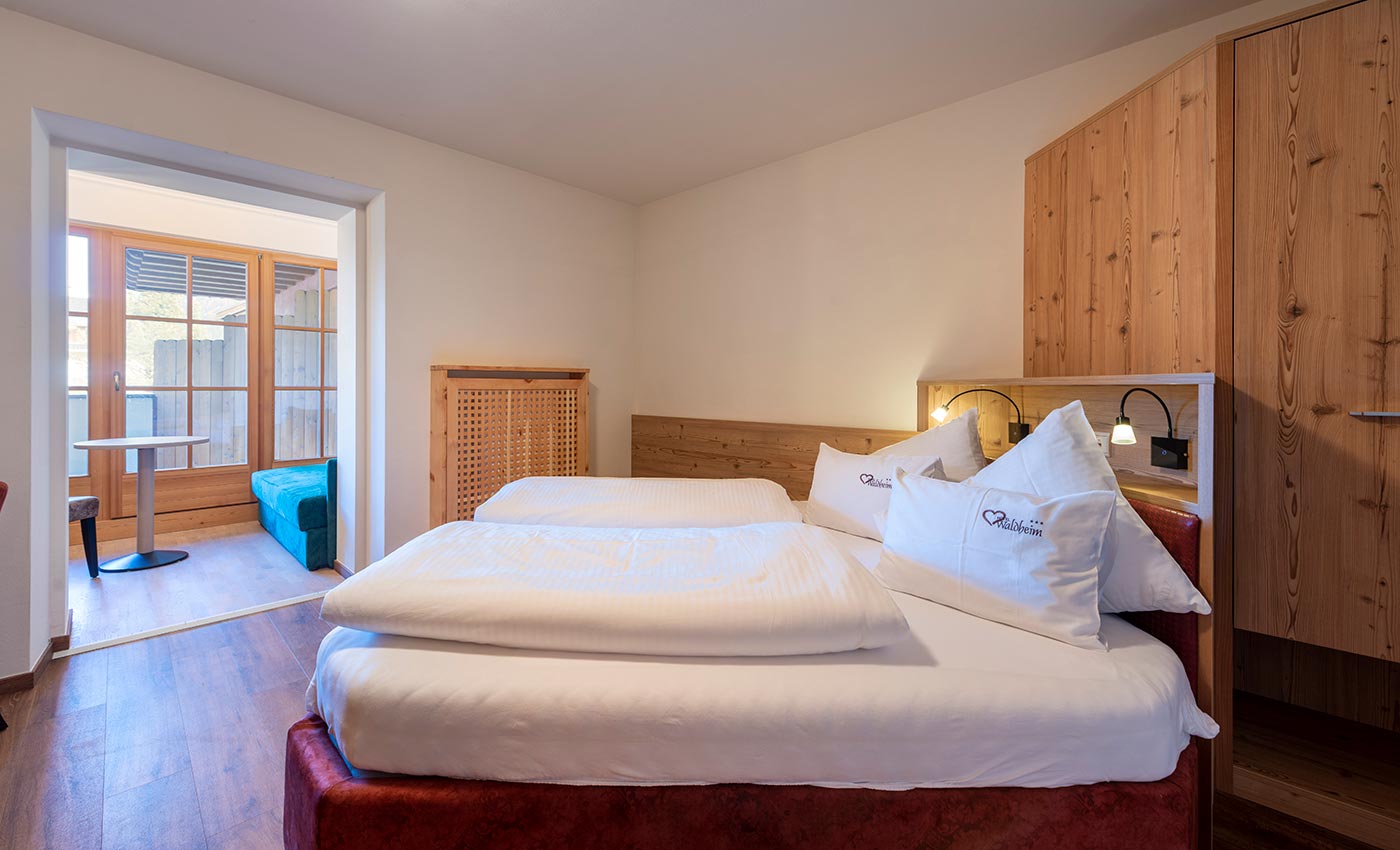 Interior of a room at the Waldheim Hotel in Italy: red carpeting and natural wood furniture