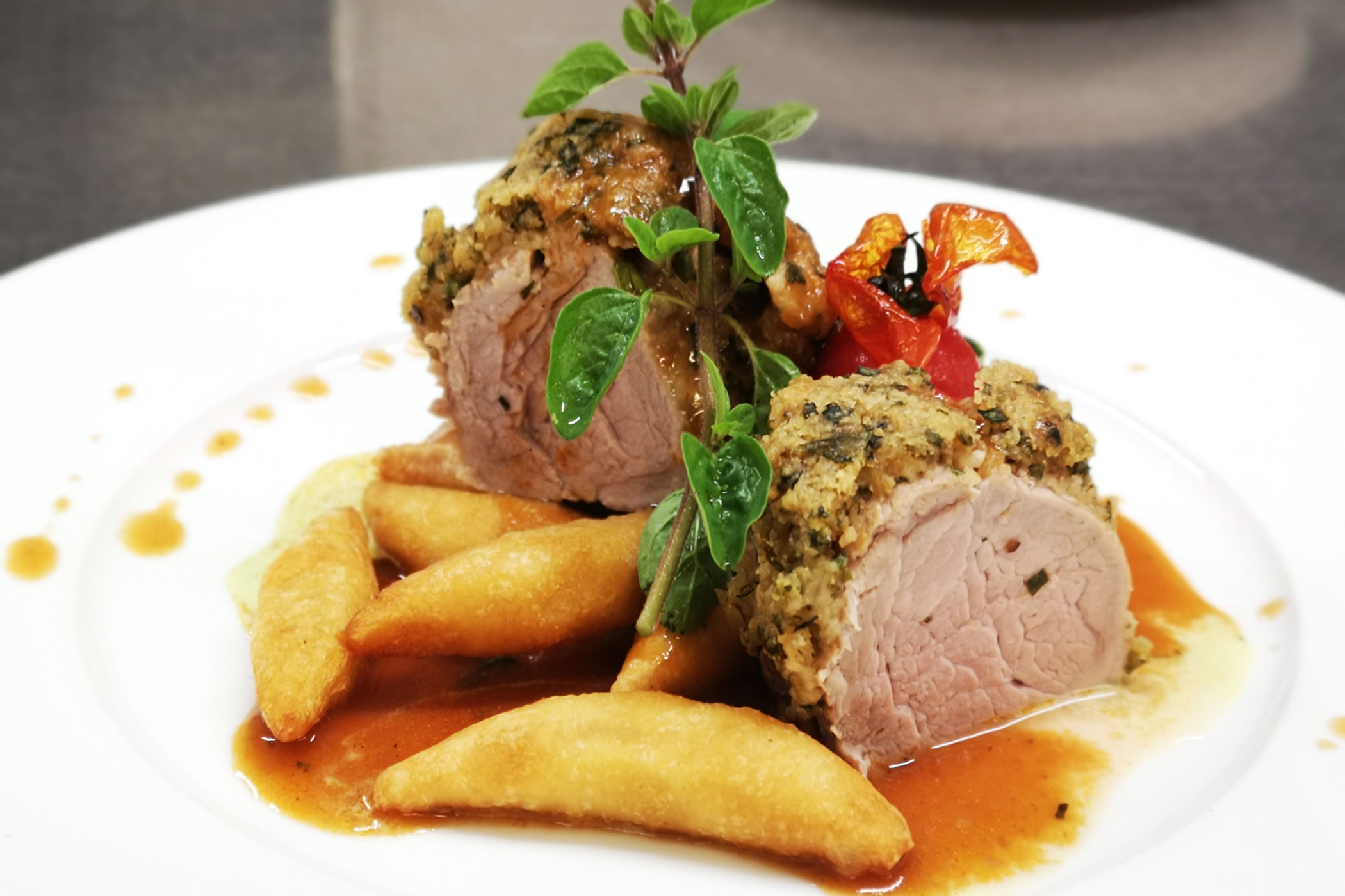 Gourmet-Gericht mit Krustenfleisch, Soße, Knödeln, Spinat, Kirschtomaten und frischer Kräutergarnitur. - Hotel Waldheim