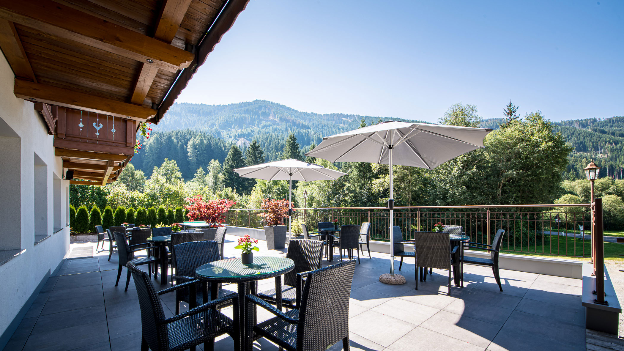 Außenansicht des Hotels Waldeim mit Balkonen und Grünflächen im Vordergrund, auf dem Schild steht 