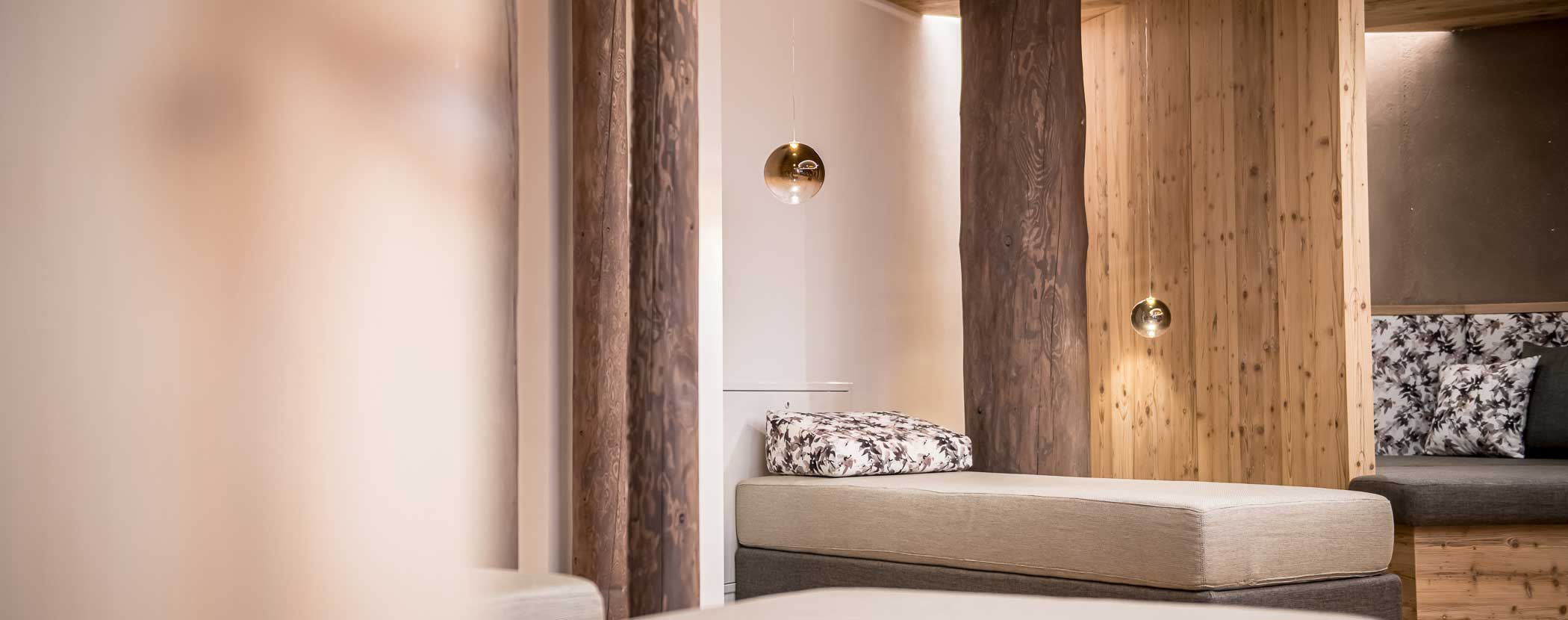 Moderner Entspannungsbereich mit gepolsterten Liegestühlen, Holzakzenten und Hängelampen. - Hotel Waldheim
